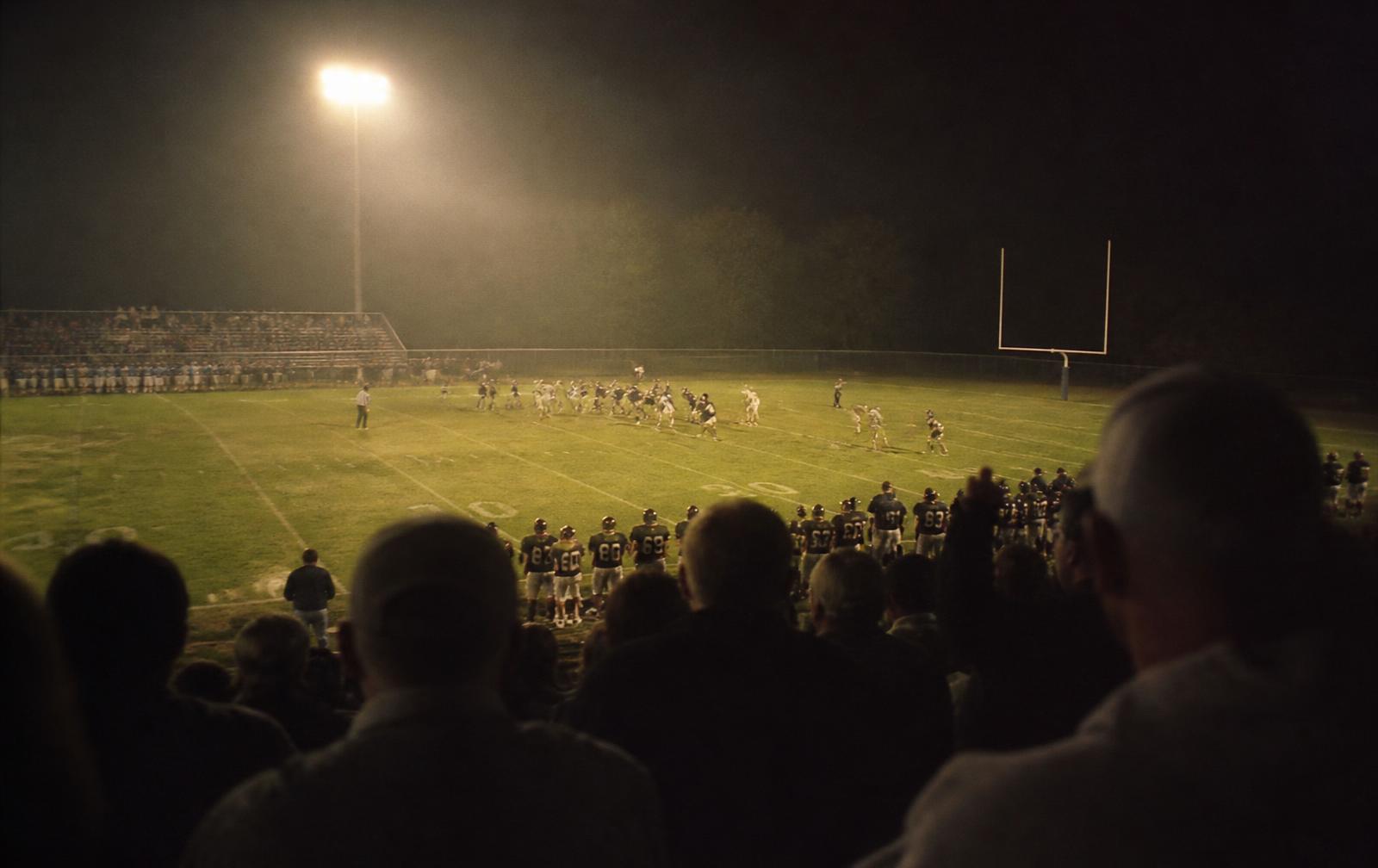 Friday night football under stadium lights in a small town